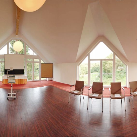 360°-Blick durch den Tagungsraum Eishaus mit Bestuhlung, Tagungstechnik und großen Panoramafenstern.