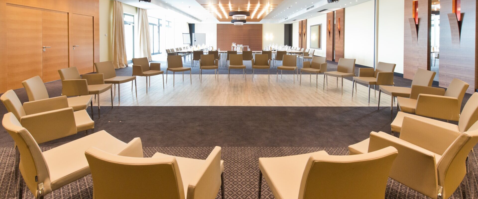 Großer Stuhlkreis im Tagungsraum Festsaal, dahinter Tagungstische in großer U-Form.