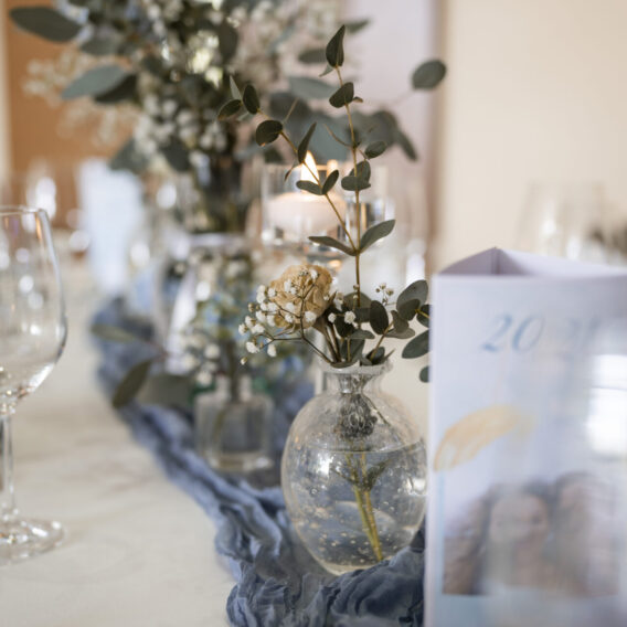 Detail mit Blumen, Kerzen und Dekoration auf einer Festtafel